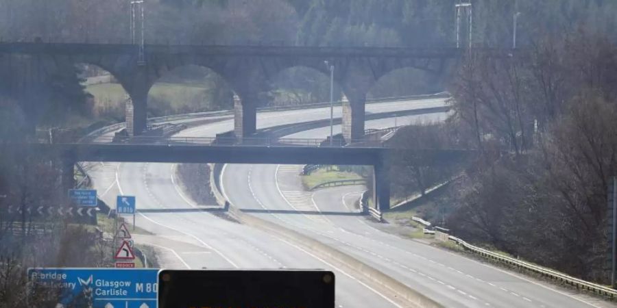 Eine digitale Anzeigentafel an einer Autobahn appelliert an die Fahrer, möglichst zu Hause zu bleiben. Foto: Andrew Milligan/PA Wire/dpa
