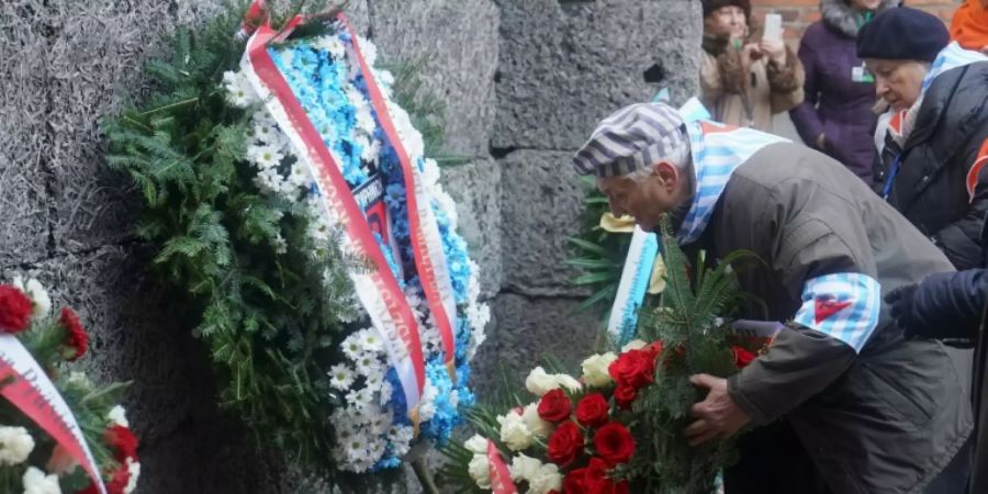Ein Holocaust-Überlebender legt in Auschwitz einen Kranz ab