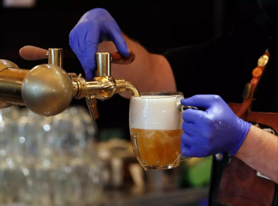 Ein Barkeeper zapft ein Bier in einem Restaurant.