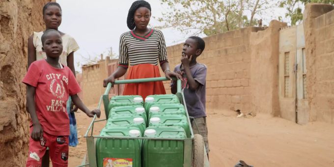 Eine Frau mit mehreren Kanister Wasser während dem Lockdown in Burkina Faso. Weil viele Menschen kilometerweite Strecken zurücklegen müssen, um Wasser zu holen, musste umgedacht werden. Burkina Faso