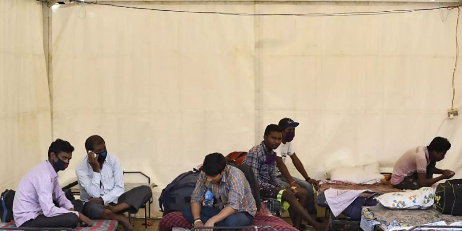 Wanderarbeiter warten im nordostindischen Guwahati auf den Bus, der sie in ihre Heimatorte bringen soll. Foto: David Talukdar/ZUMA Wire/dpa