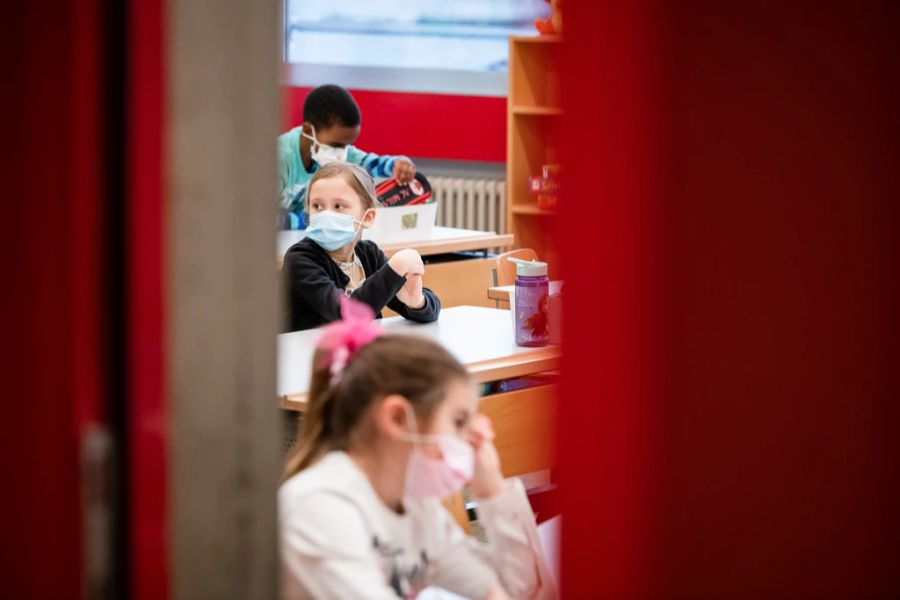 Kinder der ersten Klasse der Grundschule von Chiasso im Klassenzimmer mit Schutzmaske.