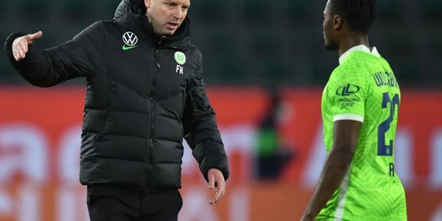 Wolfsburgs Trainer Florian Kohfeldt (l) klatscht mit seinem Spieler Ridle nach dem 0:0 gegen die Hertha ab. Foto: Swen Pförtner/dpa