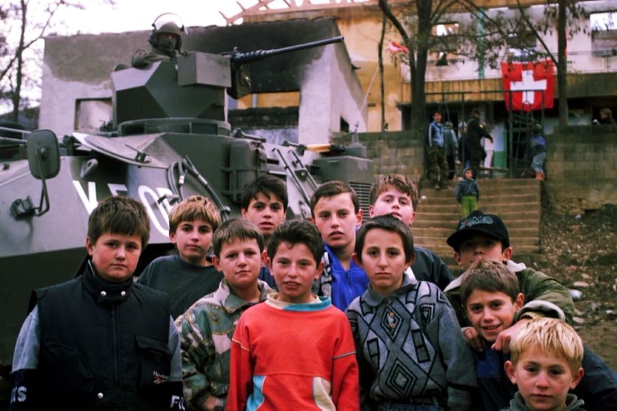 Nach dem Krieg unterstützte die Schweizer Armee im Kosovo den Wiederaufbau. Hier Kinder vor einer Schule mit der Schweizer Flagge im Hintergrund am 24. November 1999.