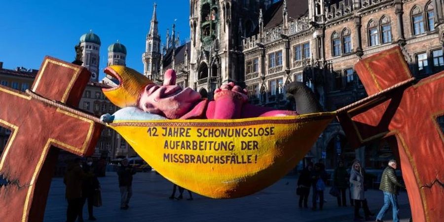 Die Plastik „Der Hängemattenbischof“ steht auf dem Marienplatz in München. Foto: Sven Hoppe/dpa