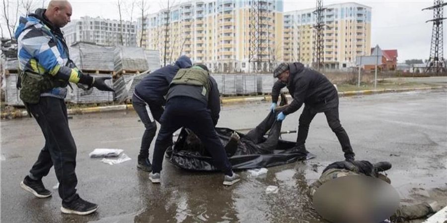 Helfer transportieren einen im Ukraine-Krieg erschossenen Zivilisten in Butscha.