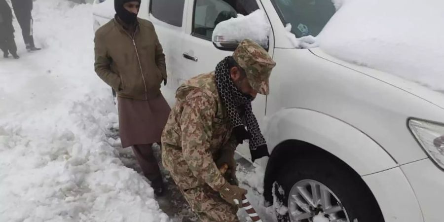 Nichts geht mehr, ein Soldat hilft: Nach einem heftigen Wintereinbruch im Norden Pakistans sind mindestens 21 Urlauber ums Leben gekommen. Foto: -/Inter Services Public Relations/AP/dpa