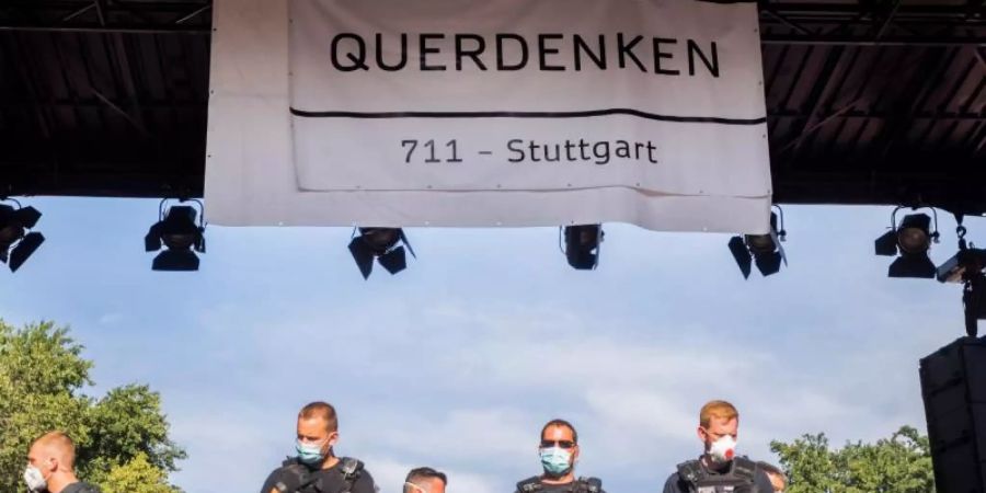 Polizisten stehen bei einer Kundgebung gegen die Corona-Beschränkungen auf der Strasse des 17. Juni in Berlin auf der Bühne unter dem Banner der Initiative «Querdenken 711». Die Polizei hatte die Veranstaltung aufgelöst. Foto: Christoph Soeder/dpa