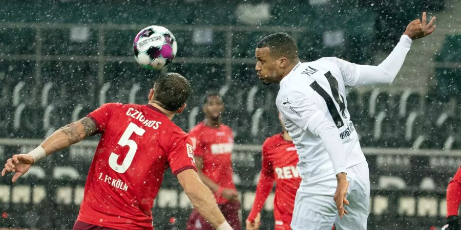 Gladbachs Alassane Plea (r.) und der Kölner Rafael Czichos versuchen den Ball zu spielen.