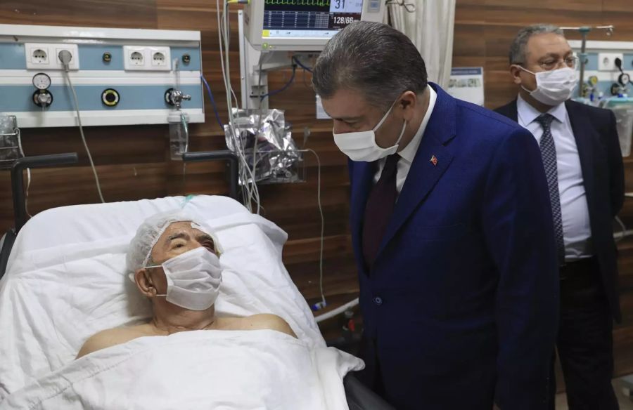 Der türkische Gesundheitsminister Fahrettin Koca mit Erdbeben-Opfer Ahmet Citim (70), der nach 33 Stunden aus den Trümmern geborgen wurde.