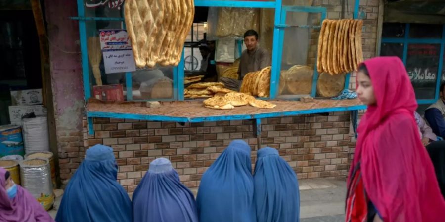 Frauen in Burkas warten vor einer Kabuler Bäckerei