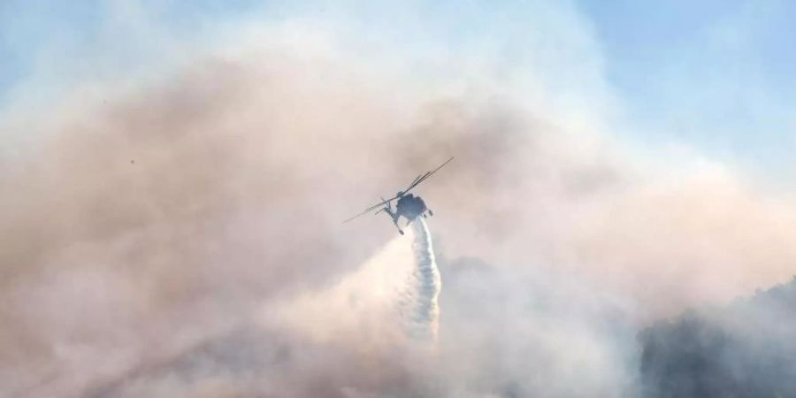 Ein Löschhubschrauber ist in Keratea südöstlich von Athen im Einsatz. Foto: Marios Lolos/XinHua/dpa