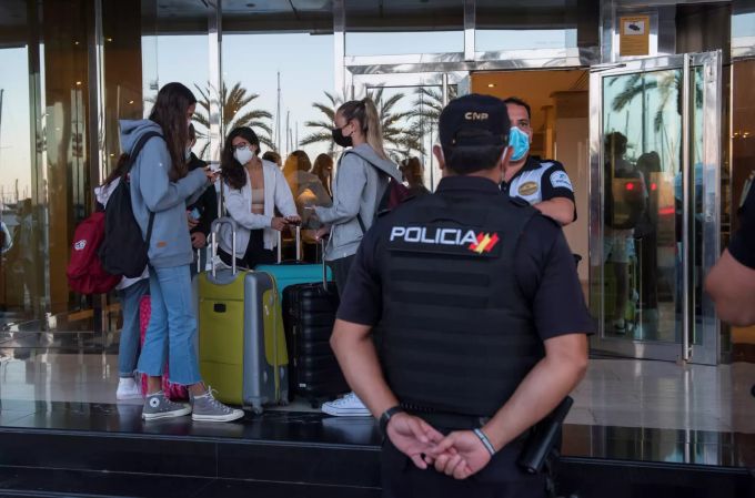 Ein Polizist beobachtet Touristen auf Mallorca. Wegen des Coronavirus soll nun das Militär aushelfen. Coronavirus