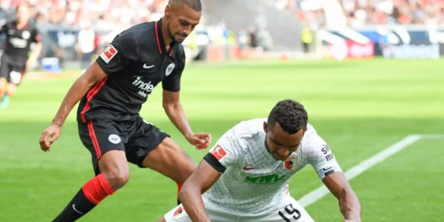 Frankfurts Djibril Sow (l) und Augsburgs Felix Uduokhai kämpfen um den Ball. Foto: Arne Dedert/dpa
