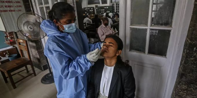 Gesundheitspersonal nimmt an einer Frau einen Nasen-Rachen-Abstrich in Mumbai. Coronavirus India