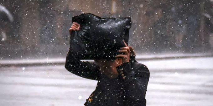 Eine Fussgängerin versucht sich mit ihrer Tasche vor dem Regen zu schützen. (Symbolbild) Wetter Regen