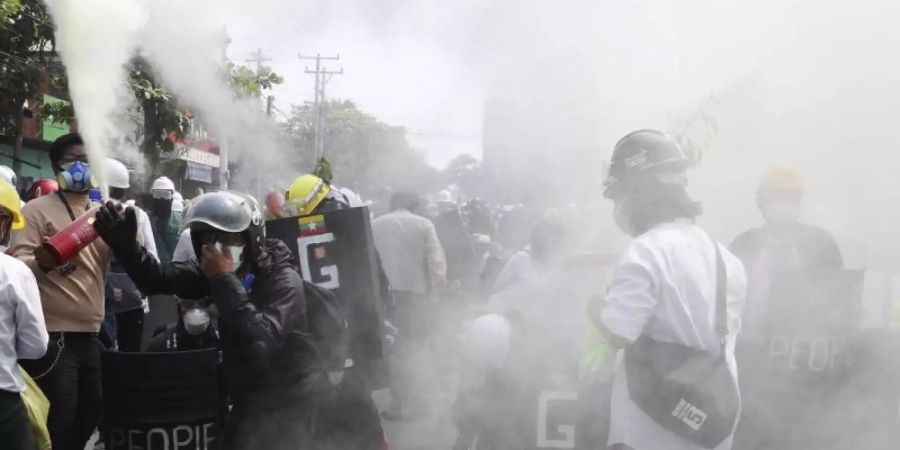 Anti-Putsch-Demonstranten entladen Feuerlöscher, um während einer Demonstration in Mandalay den Auswirkungen des von der Polizei abgefeuerten Tränengases entgegenzuwirken. Foto: Uncredited/AP/dpa