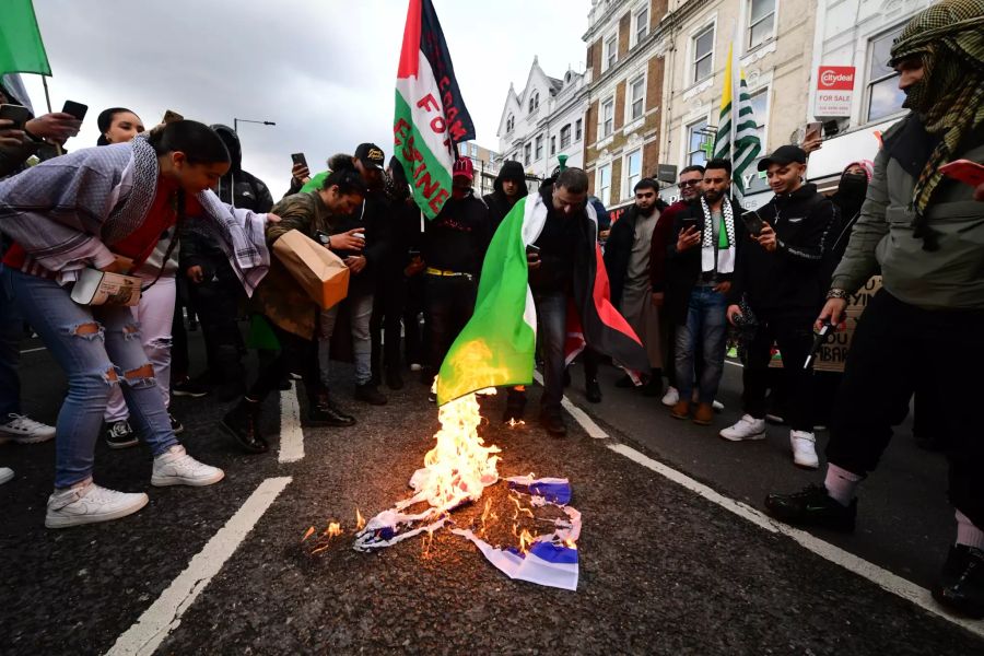 Demonstranten verbrennen eine israelische Flagge in Kensington, während eines Marsches in Solidarität mit Palästina.Foto: Ian West/PA Wire