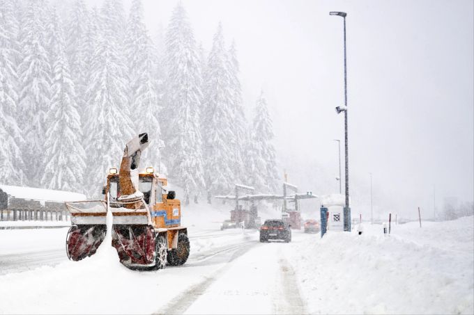 Ein Schneepflug raeumt Schnee von der Strasse vor dem Portal des Autoverlads Vereina vor dem Portal in Klosters am Sonntag, 22. Dezember 2024 in Klosters (Symbolbild). wetterjahr