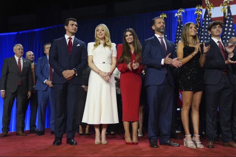 Von links nach rechts: Michael Boulos steht neben seiner Frau Tiffany Trump (in Weiss). Die Frau im roten Kleid ist Kimberly Guilfoyle. Sie steht neben ihrem Verlobten,  Donald Trump J. Daneben steht Trumps Enkelin Kai (Minikleid).