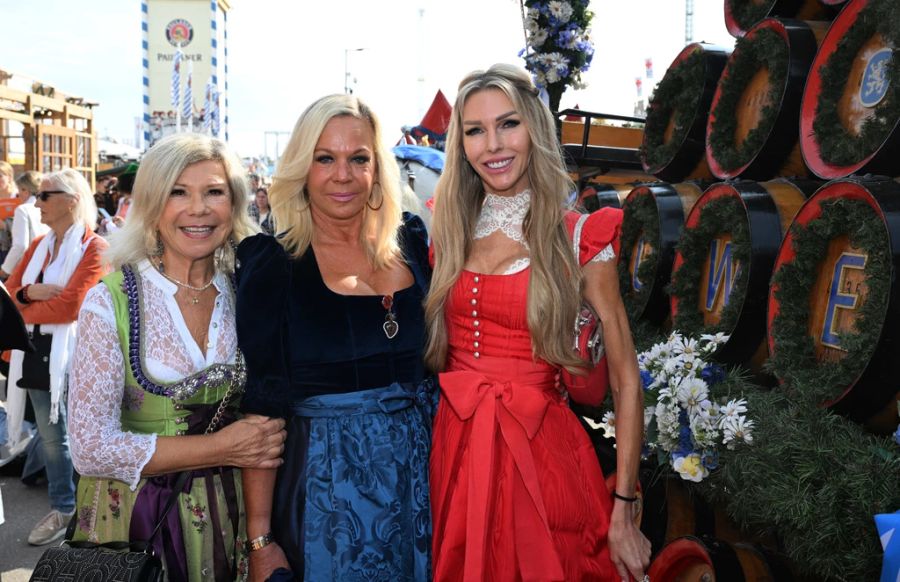 Die Sängerin Marianne Hartl (Marianne und Michael), die Agenturi-Inhaberin Birgit Fischer-Höper und Moderatorin Sabine Piller stehen vor dem Schützenzelt im Rahmen der Damenwiesn.