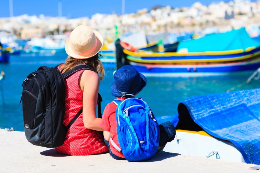 Mutter und Sohn sitzen am Hafen in den Ferien