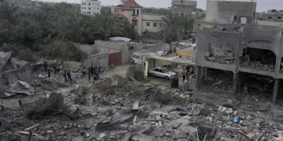 ARCHIV - Palästinenser betrachten die Trümmer eines Gebäudes, das bei einer israelischen Bombardierung zerstört wurde. Foto: Hatem Moussa/AP/dpa