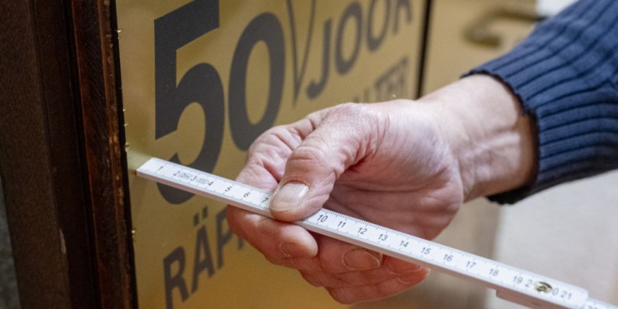 Risiko-Inspektoren prüfen die Breite der Notausgänge in einem Guggenmusik-Keller in Basel.