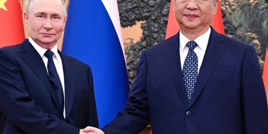ARCHIV - Der russische Präsident Wladimir Putin (l) und der chinesische Präsident Xi Jinping geben sich vor ihrem Treffen in der Großen Halle des Volkes die Hand. Foto: Sergei Bobyle...