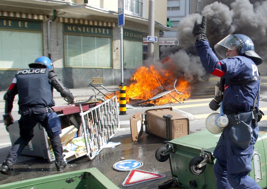 Polizisten räumen am 1. Juni 2003 in Lausanne eine Kreuzung nach Ausschreitungen mit gewalttätigen Anti-G8-Demonstranten.