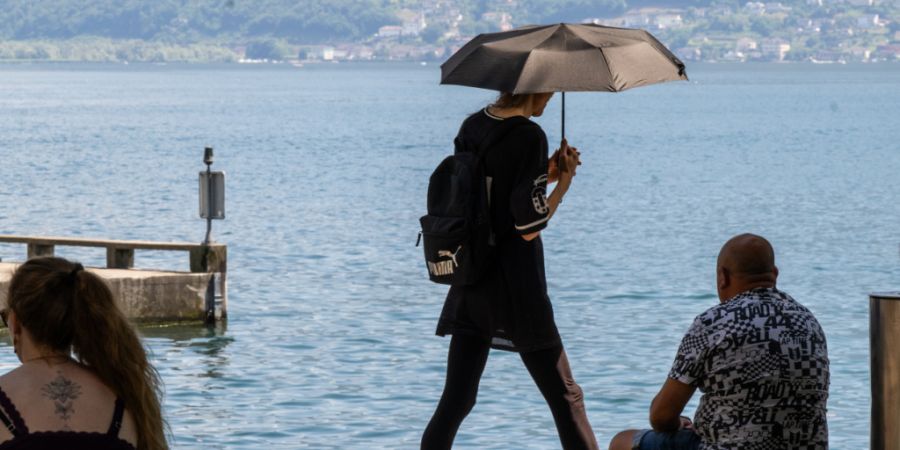 Für einen Grossteil des Tessins gilt erhebliche Hitzegefahr: Ein Schirm schützt nicht nur vor Regen, sondern auch vor der Sonne. (Archivbild)