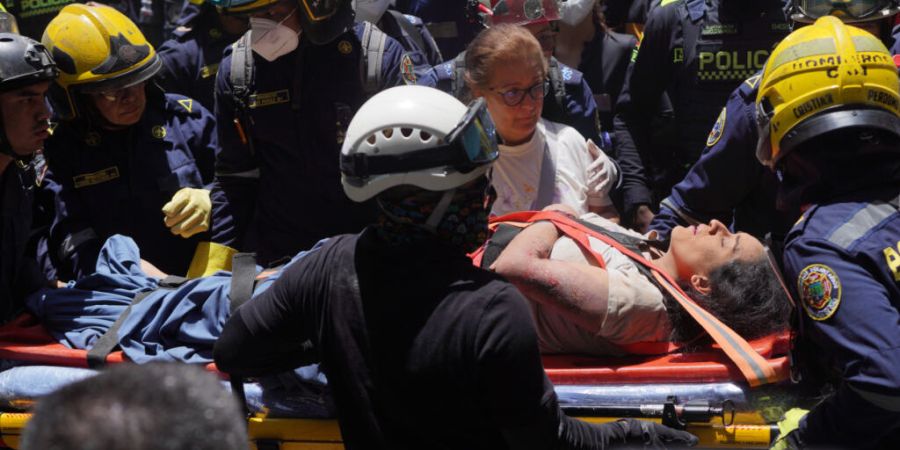 Rettungskräfte tragen Diana Troncoso, nachdem sie am Tag nach dem Erdbeben aus den Trümmern geborgen wurde. Foto: Ivan Valencia/AP/dpa