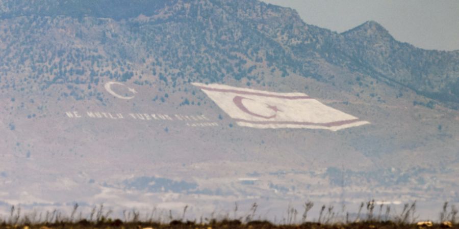 ARCHIV - Die Nachbildung einer Flagge der türkischen Republik Nordzypern an den Hängen des Berges Pentadaktylos. Foto: Christoph Reichwein/dpa/Archivbild
