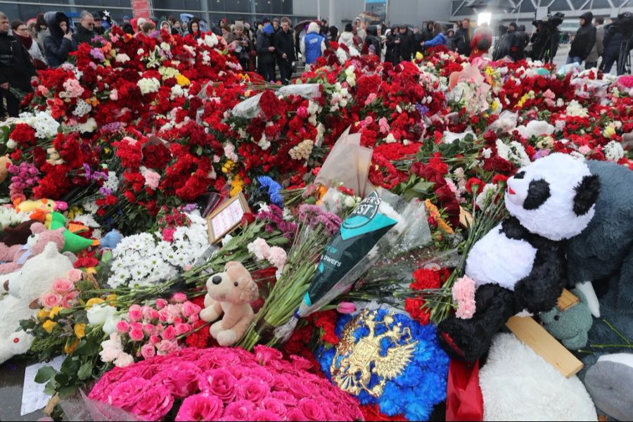 Zahlreiche Menschen legen vor der Konzerthalle Blumen für die Opfer des Terroranschlags nieder.