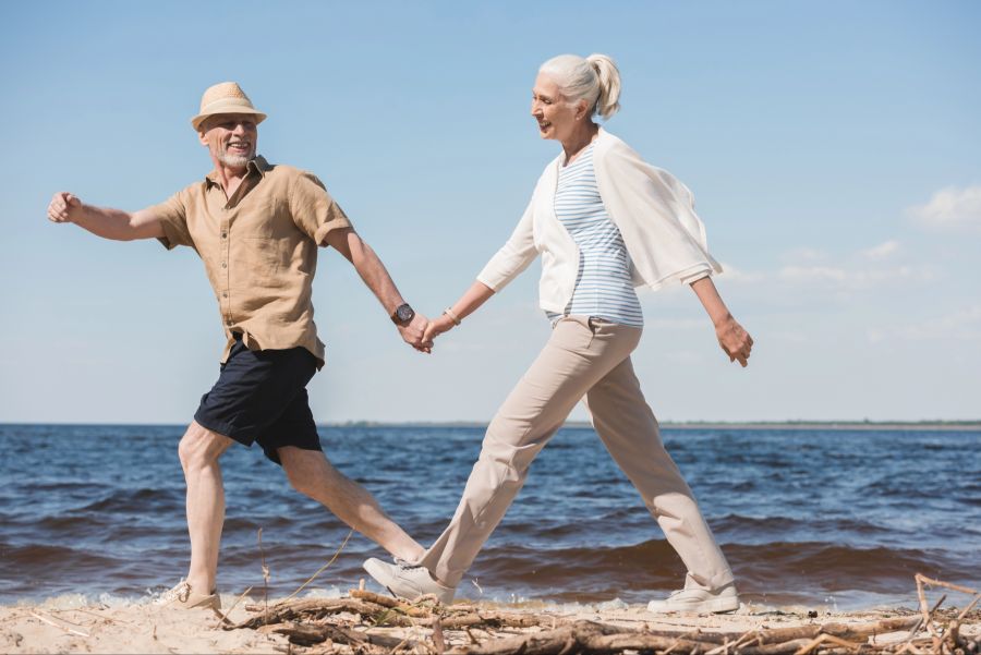 Mann und Frau laufen am Wasser entlang