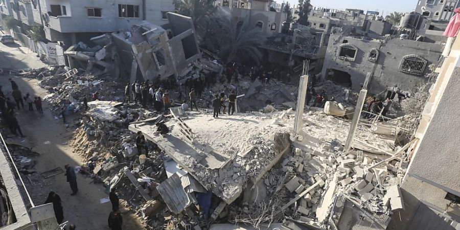 Menschen suchen in den Trümmern eines Gebäudes nach Überlebenden des israelischen Bombardements. Foto: Hatem Ali/AP