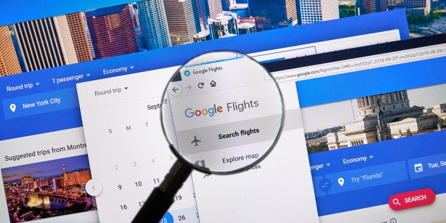 Eine Lupe über einem Bildschirm, der Google Flights anzeigt.