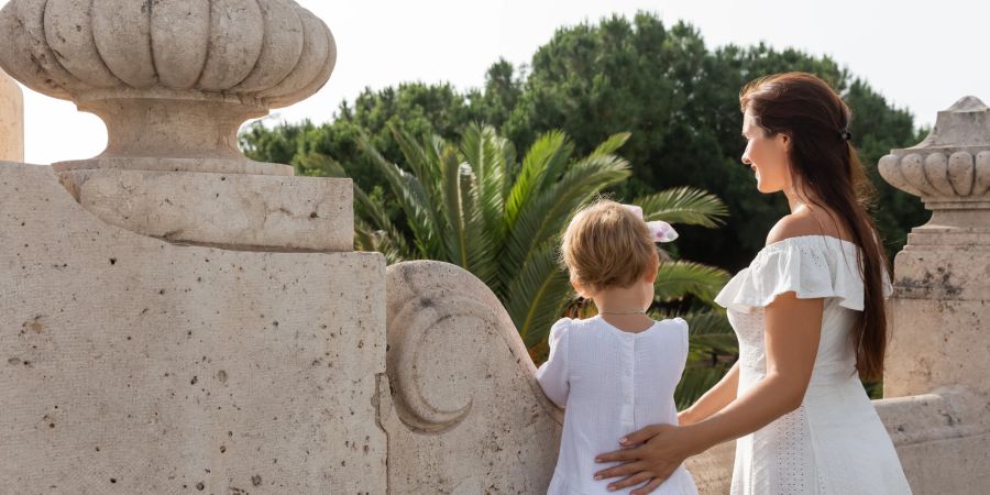 Frau und Kind in weissen Kleidern im Urlaub.