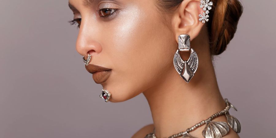 Exotisches Model mit viel Schmuck und braunen Lippen.