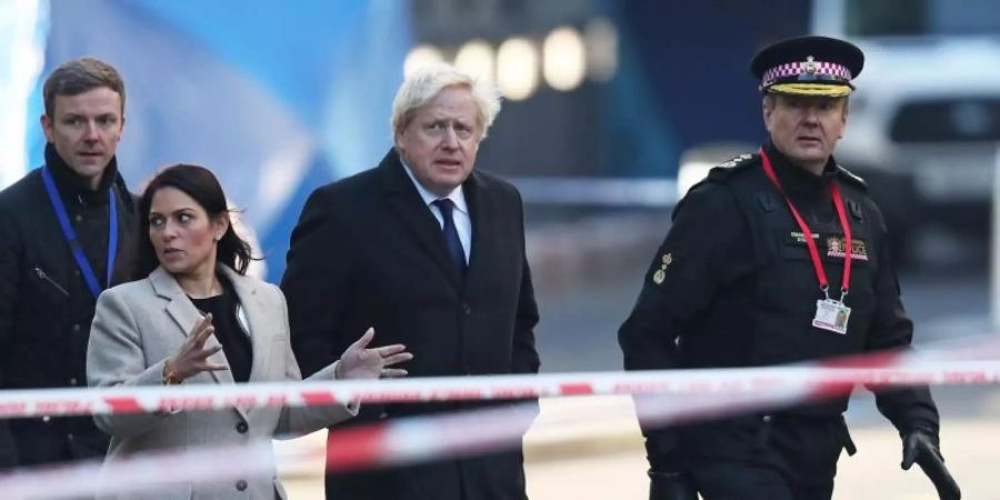 Boris Johnson zusammen mit Innenministerin Priti Patel und Polizisten am Ort der Bluttat auf der London Bridge. Foto: Steve Parsons/PA Wire/dpa