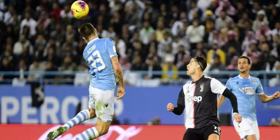 Lazios Francesco Acerbi (l) spielt den Ball neben Turins Christiano Ronaldo (M). Foto: Nasser Alharbi/AP/dpa