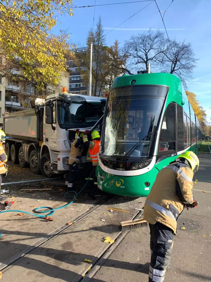 Die Berufsfeuerwehr der Rettung Basel-Stadt ist am Unfallort im Einsatz. tram lastwagen