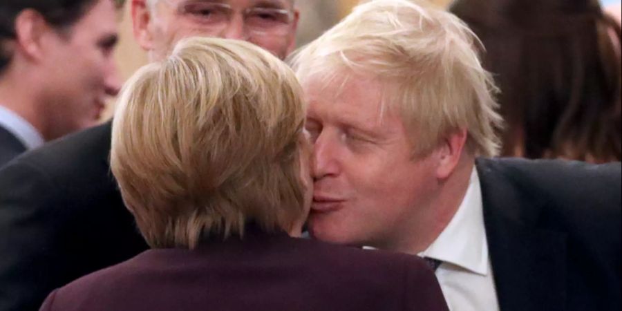 Boris Johnson, Premierminister von Grossbritannien, begrüsst Bundeskanzlerin Angela Merkel (CDU) während eines Empfangs im Buckingham Palace.