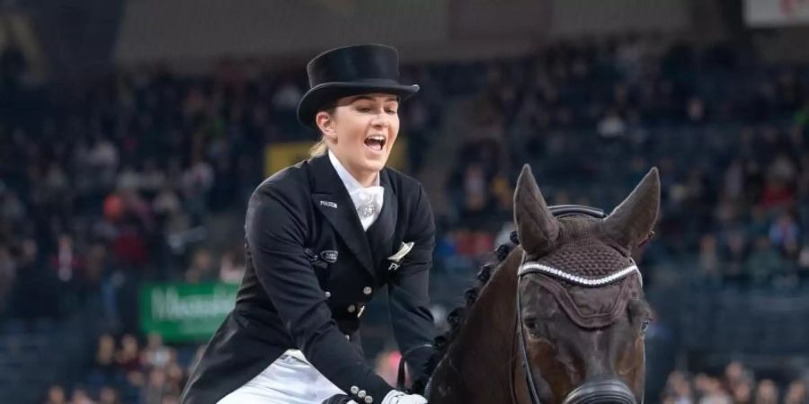 Lisa Müller feiert ihren ersten Platz auf ihrem Pferd Stand by me. Foto: Sebastian Gollnow/dpa