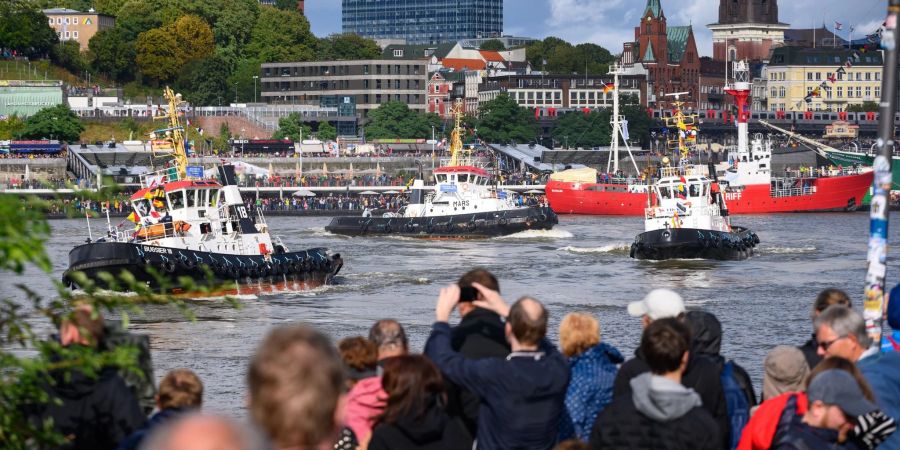 Schaulustige beobachten das traditionelle Schlepperballett auf der Elbe.