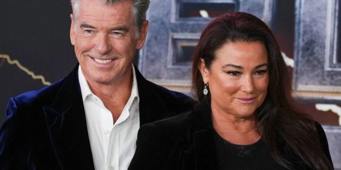 Pierce Brosnan und seine Frau Keely Shaye Smith grinsen verschmitzt auf dem roten Teppich. Pierce Brosnan