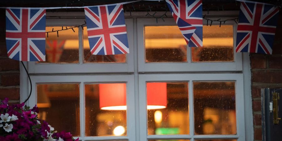 Union-Jack-Fahnen am eines Pubs in London. In der Glitzermetroploe schliessen die Pubs meist um 22 Uhr.