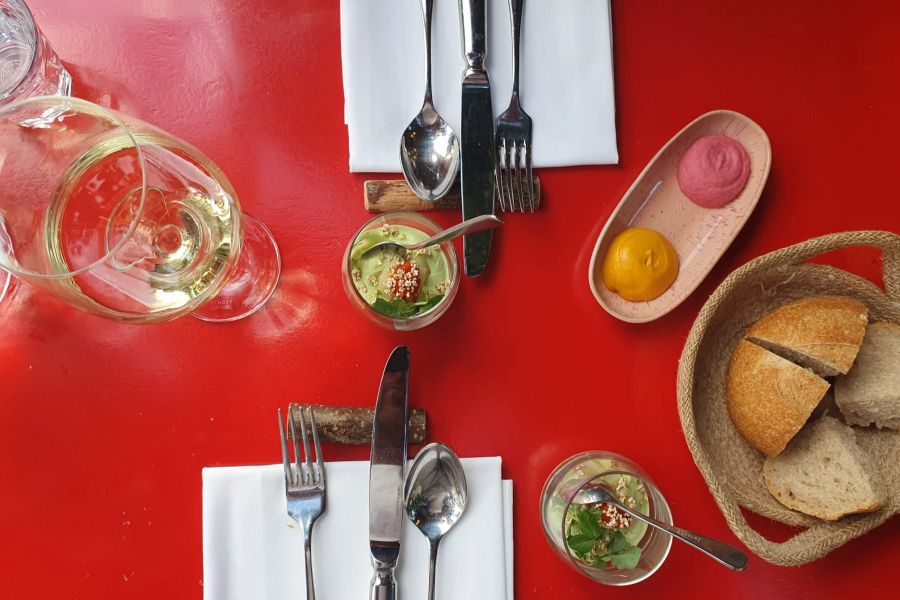 Amuse–Bouche: Avocado-Crème im Glas, dazu warm knuspriges Hausbrot mit Dips.