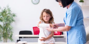 Kind mit Verband beim Arzt