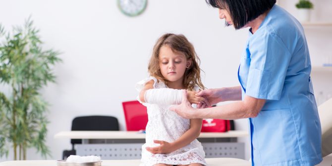 Kind mit Verband beim Arzt